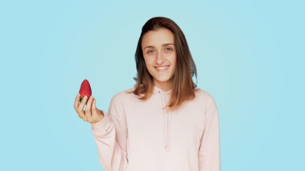Healthy young woman bites tasty red strawberry - Imágenes, Vídeo