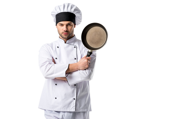 Porträt eines jungen Kochs in Uniform mit Pfanne auf weißem Hintergrund - Foto, Bild