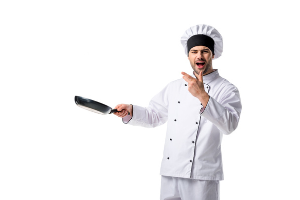 portrait of emotional young chef in uniform with frying pan isolated on white - Foto, Imagen