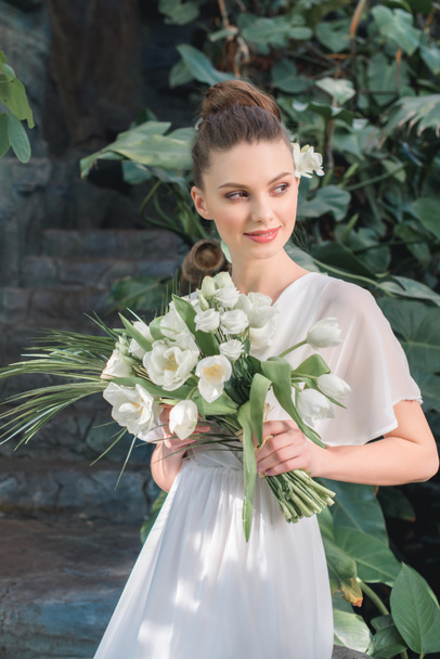 beautiful bride posing in white dress with wedding bouquet - Zdjęcie, obraz