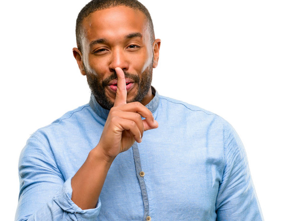 Αφρικανικός Αμερικανός άνδρας με γενειάδα με το δάχτυλο στα χείλη, να ζητήσω να είναι ήσυχο. Σιωπή και μυστικό έννοια απομονωθεί σε λευκό φόντο - Φωτογραφία, εικόνα