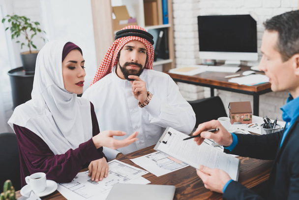 Realtor reading terms of purchase and sale agreement for young Muslim couple  - Foto, immagini