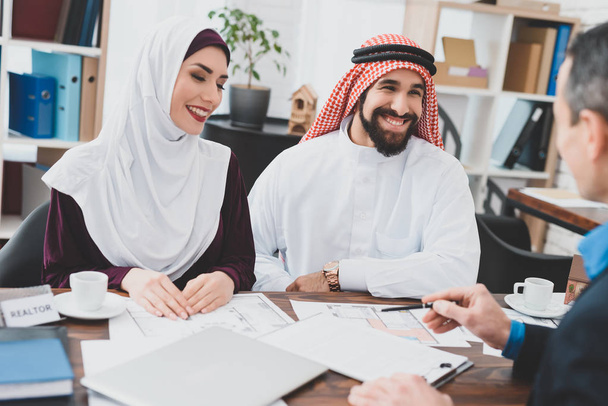 Realtor telling about terms of purchase and sale agreement for young Arab couple  - 写真・画像