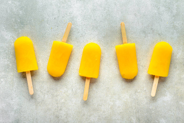 Homemade popsicles with orange juice, ice lollies on sticks, top view flat lay - Foto, immagini