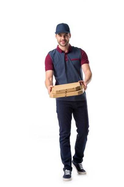 smiling delivery man with cardboard pizza boxes isolated on white - Foto, imagen