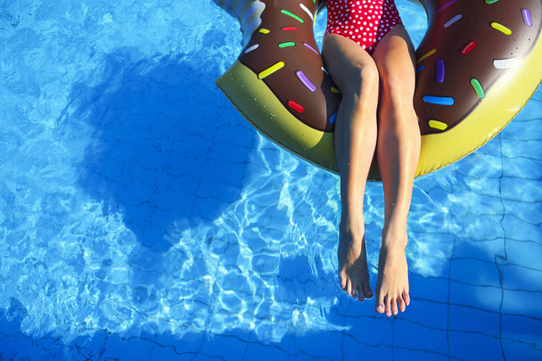 Mujer joven en colchón inflable en la piscina
 - Foto, imagen