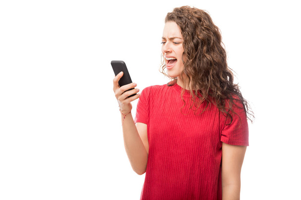 Furious young woman yelling at her mobile phone isolated on white background - Fotografie, Obrázek