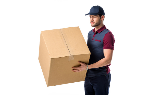 vista lateral do homem de entrega na tampa com caixa de papelão em mãos isoladas em branco
 - Foto, Imagem