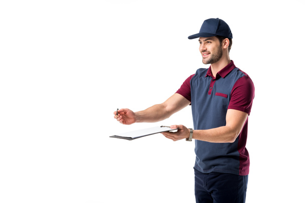 smiling delivery man with pen and notepad isolated on white - Фото, изображение