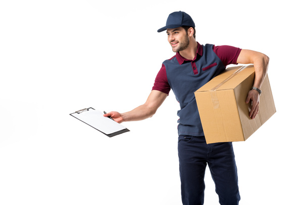 smiling delivery man with cardboard box, empty notepad and pen isolated on white - Photo, Image