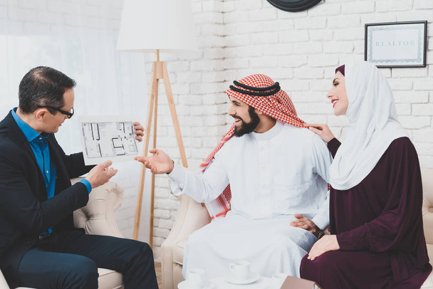 realtor showing house plan for Arab couple in real estate agency - Foto, Imagem