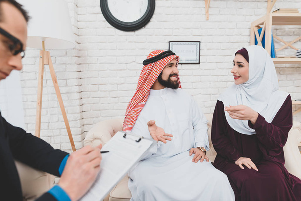 Arab couple discussing buying house while realtor preparing documents - Fotó, kép