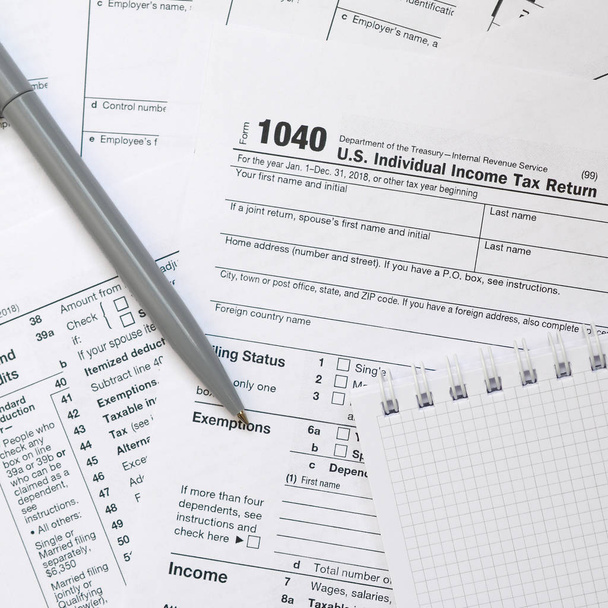 Το στυλό και το σημειωματάριο είναι ψέματα σχετικά με τον φόρο αποτελούν 1040 ΗΠΑ ατομική φορολογική δήλωση. Η ώρα να πληρώνουν φόρους - Φωτογραφία, εικόνα