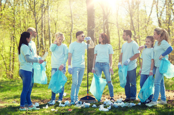 group of volunteers with garbage bags in park - Foto, Bild