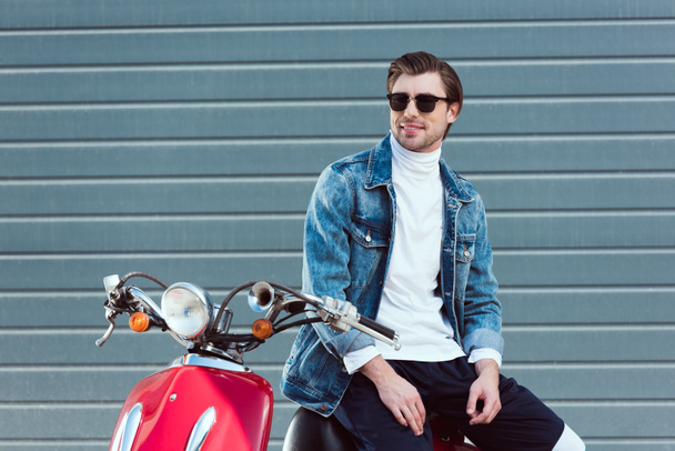 happy young man in denim jacket on vintage red scooter - Photo, Image