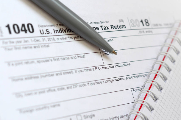 Długopis i Notes jest leży na podatek formularza 1040 indywidualnego podatku dochodowego Stanów Zjednoczonych. Czas, aby płacić podatki - Zdjęcie, obraz