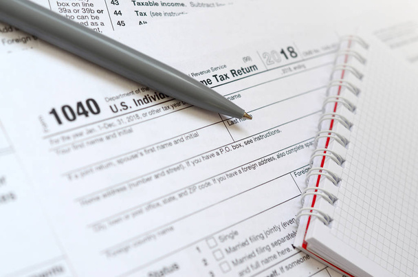 La penna e il taccuino sono bugie sul modulo fiscale 1040 Stati Uniti Dichiarazione dei redditi individuale. Il tempo di pagare le tasse
 - Foto, immagini