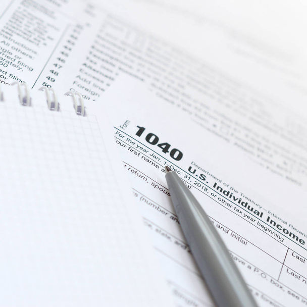 La penna e il taccuino sono bugie sul modulo fiscale 1040 Stati Uniti Dichiarazione dei redditi individuale. Il tempo di pagare le tasse
 - Foto, immagini
