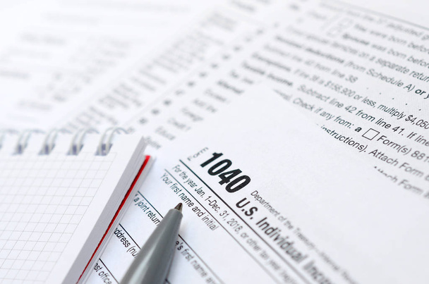 Długopis i Notes jest leży na podatek formularza 1040 indywidualnego podatku dochodowego Stanów Zjednoczonych. Czas, aby płacić podatki - Zdjęcie, obraz