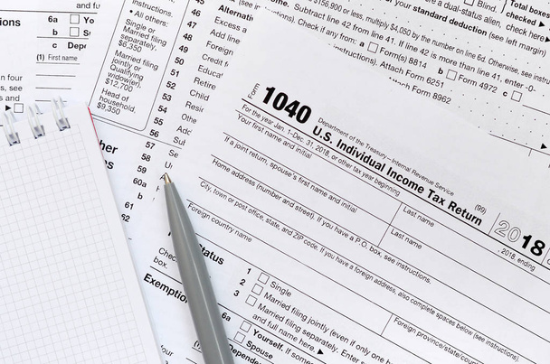 ペンとノートは、税上にあるフォーム 1040 米国個人所得税申告書です。税金を払うために時間 - 写真・画像
