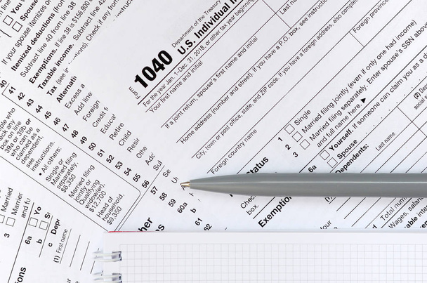Stift und Notizbuch finden sich auf dem Steuerformular 1040 / 1 der Einkommensteuererklärung. Zeit, Steuern zu zahlen - Foto, Bild