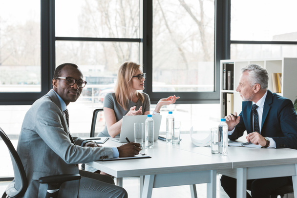professionnels multiethniques hommes d'affaires ayant une conversation lors d'une réunion d'affaires
 - Photo, image