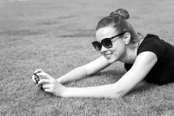 Happy girl with camera on green grass in Paris, France - Foto, Bild
