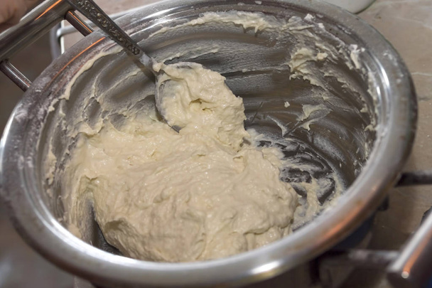We knead the dough in a saucepan, cook pancakes pancakes and fri - Fotografie, Obrázek