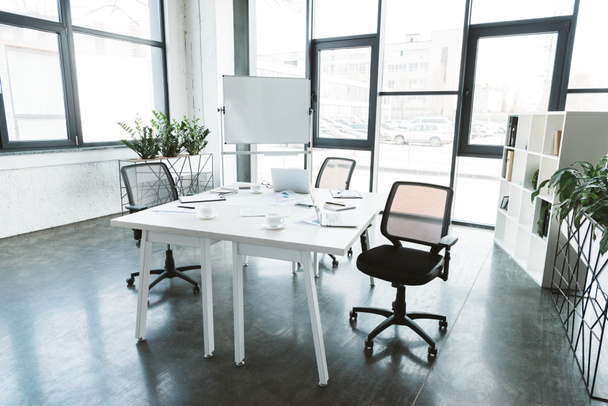 современный офисный интерьер со столом, бумагами, стульями и доской
 - Фото, изображение