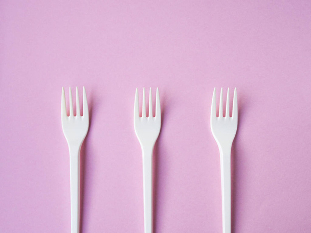 Plastic fork pattern on pink background - Foto, Imagen