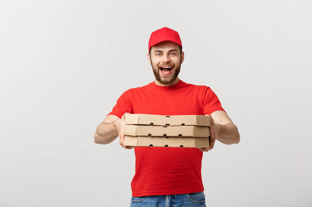 Concetto di consegna: Giovane caucasico bell'uomo di consegna pizza con scatole di pizza isolate su sfondo grigio
 - Foto, immagini