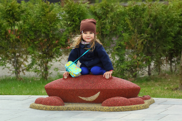 Весела дівчинка-малятко на дитячому майданчику в парку
 - Фото, зображення