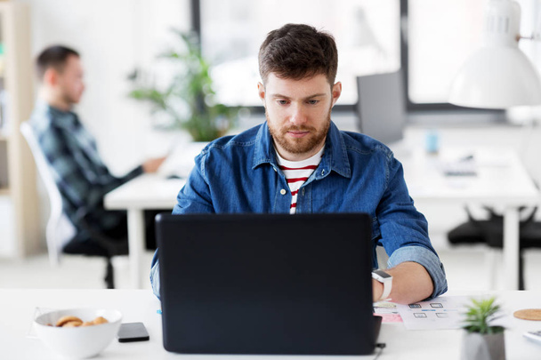 creative man with laptop working at office - Φωτογραφία, εικόνα