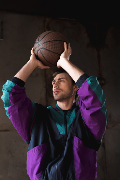 stylish young man in vintage windcheater throwing basketball ball - Foto, Bild