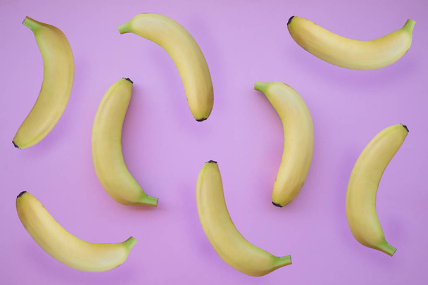 Fresh yellow bananas on pink background - Фото, изображение