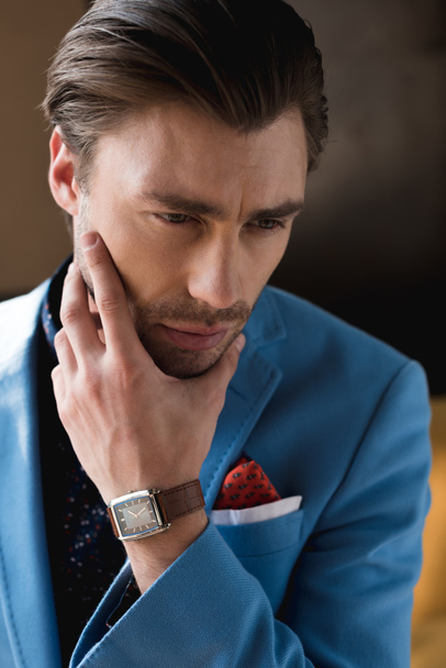 close-up portrait of thoughtful young man in stylish suit with wristwatch - Фото, изображение