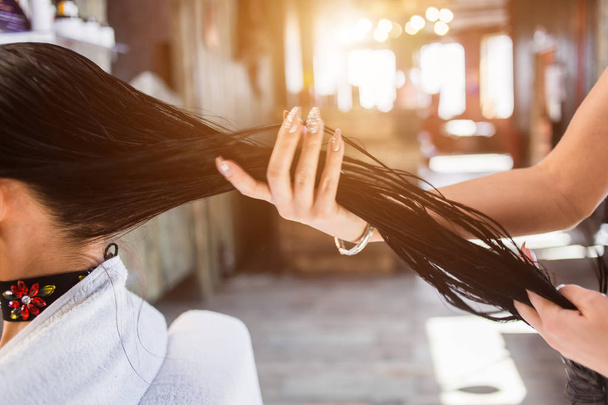 Hajápolás modern wellness szalon. fodrász nő vonatkozik egy maszk, vagy olaj a haj - Fotó, kép