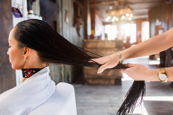 Догляд за волоссям в сучасному спа-салоні. перукарня наносить маску або олію на волосся клієнта
 - Фото, зображення