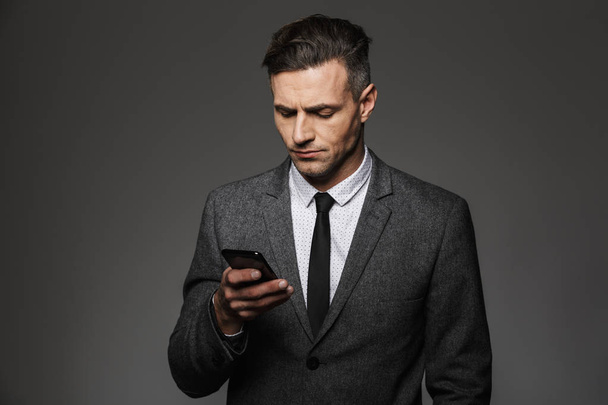 Image of young unshaved man dressed in business costume chatting - Foto, immagini