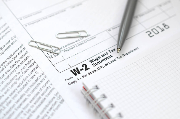 De pen en notitieblok op de belasting vormen W-2 loon- en fiscale verklaring. De tijd om te betalen belastingen - Foto, afbeelding