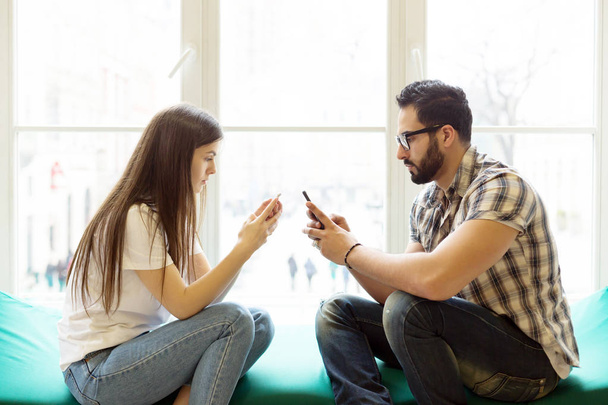 Lonely Couple Texting on Phones - Valokuva, kuva