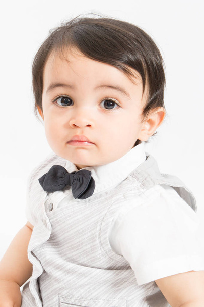 Retrato de um menino bonito olhando para a câmera com seus olhos grandes Criança adorável usando gravata borboleta
 - Foto, Imagem