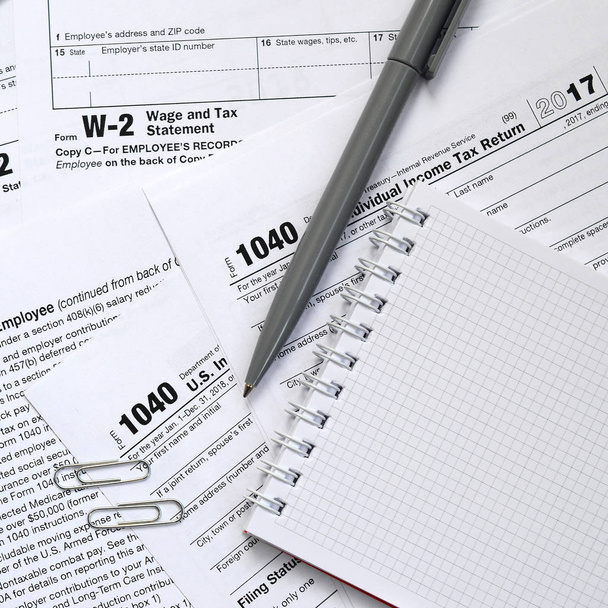 Le stylo et le cahier se trouve sur le formulaire d'impôt 1040 États-Unis Déclaration de revenus des particuliers. Le temps de payer les impôts
 - Photo, image