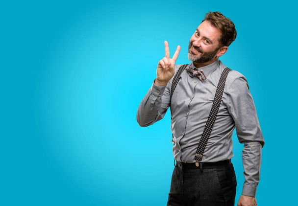 Middle age man, with beard and bow tie raising fingers, number two - Foto, afbeelding