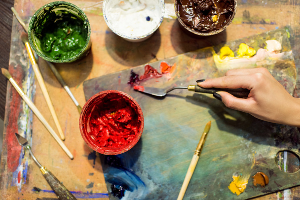 cropped image of artist applying paint on palette in workshop - Valokuva, kuva