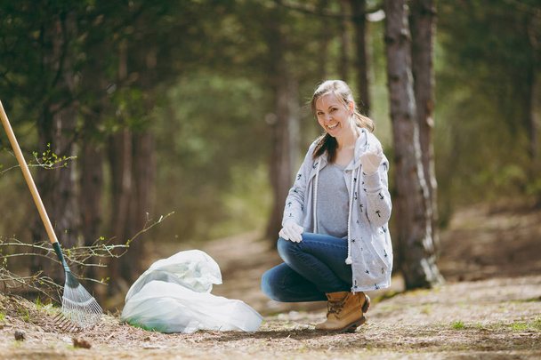 Mladá usměvavá žena čištění odpadky do koše a zobrazení - Fotografie, Obrázek