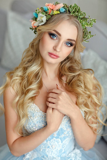 Portrait of a blue-eyed very beautiful blond girl with a wreath  - Photo, image