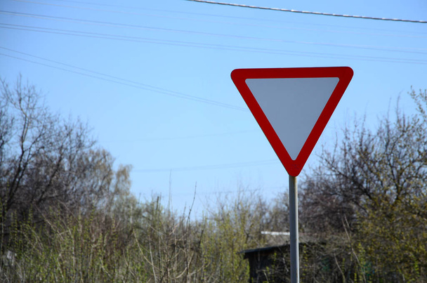Traffic sign in the form of a white triangle. Give way - Photo, Image