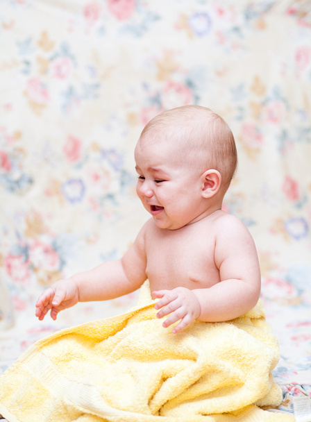 Bebé llorando en una toalla amarilla
 - Foto, Imagen