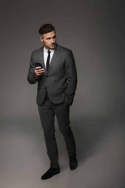 Full-length image of confident business man wearing suit and tie - Fotó, kép